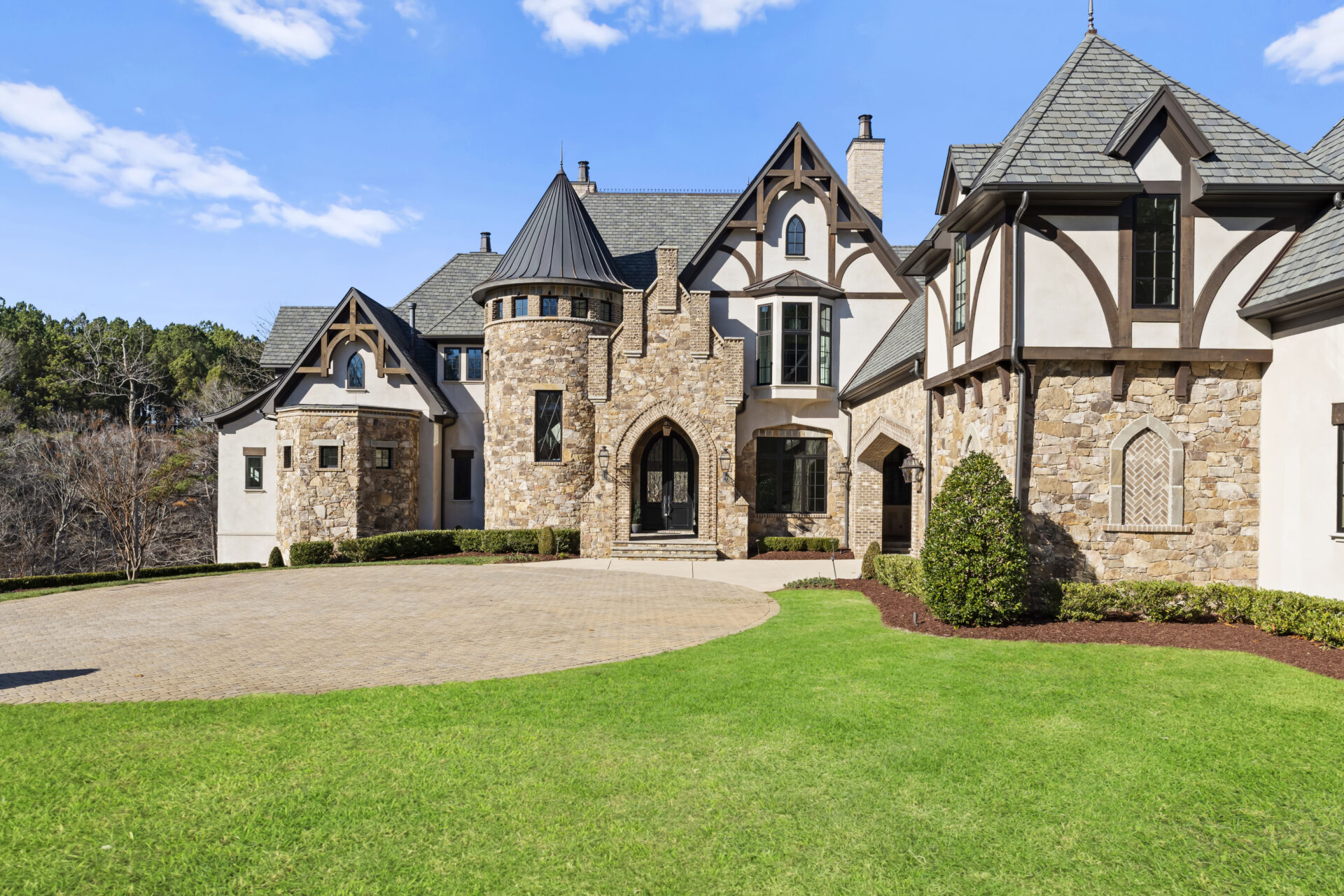 Home Page_Christian McCaffrey Tudor-style stone and stucco luxury home with turret and circular driveway, staged by Creative Home Stagers for Christian McCaffrey's Charlotte, NC residence